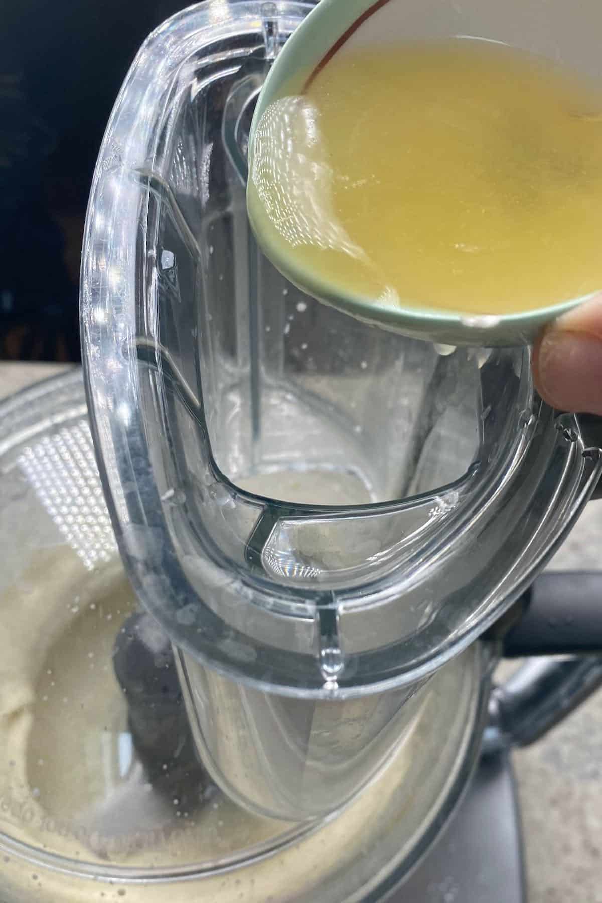 Adding lemon juice to a food processor