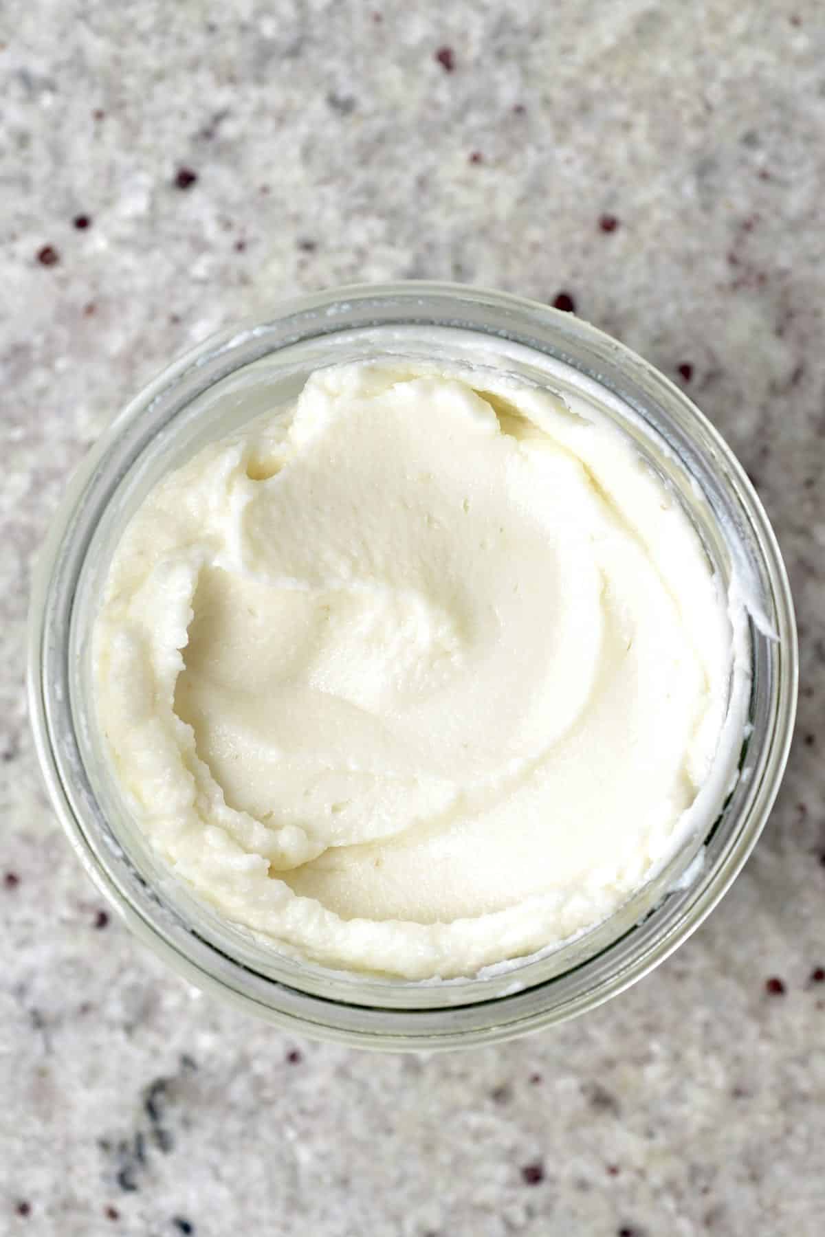 Top view of an open jar filled with garlic sauce
