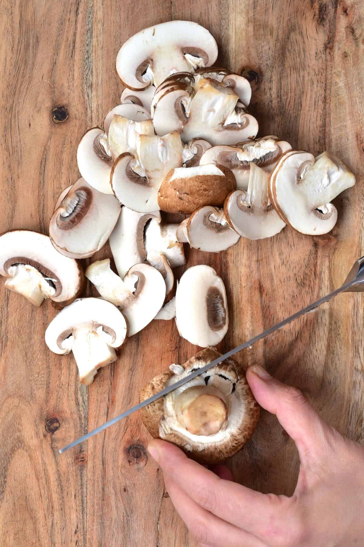 Slicing mushrooms on a wooden chopping board