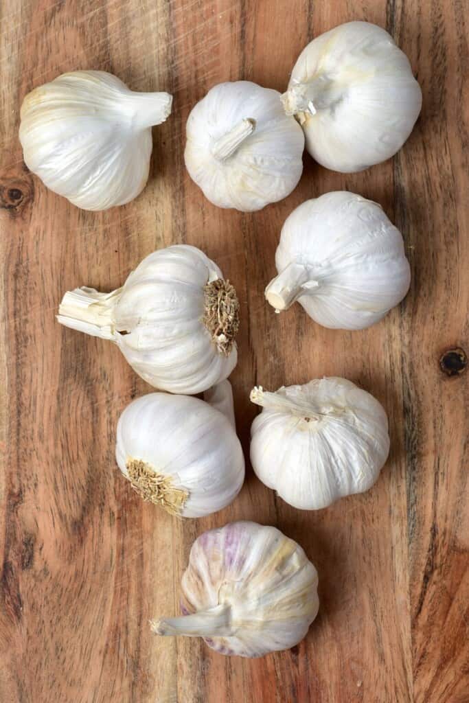 Eight garlic heads on a wooden surface