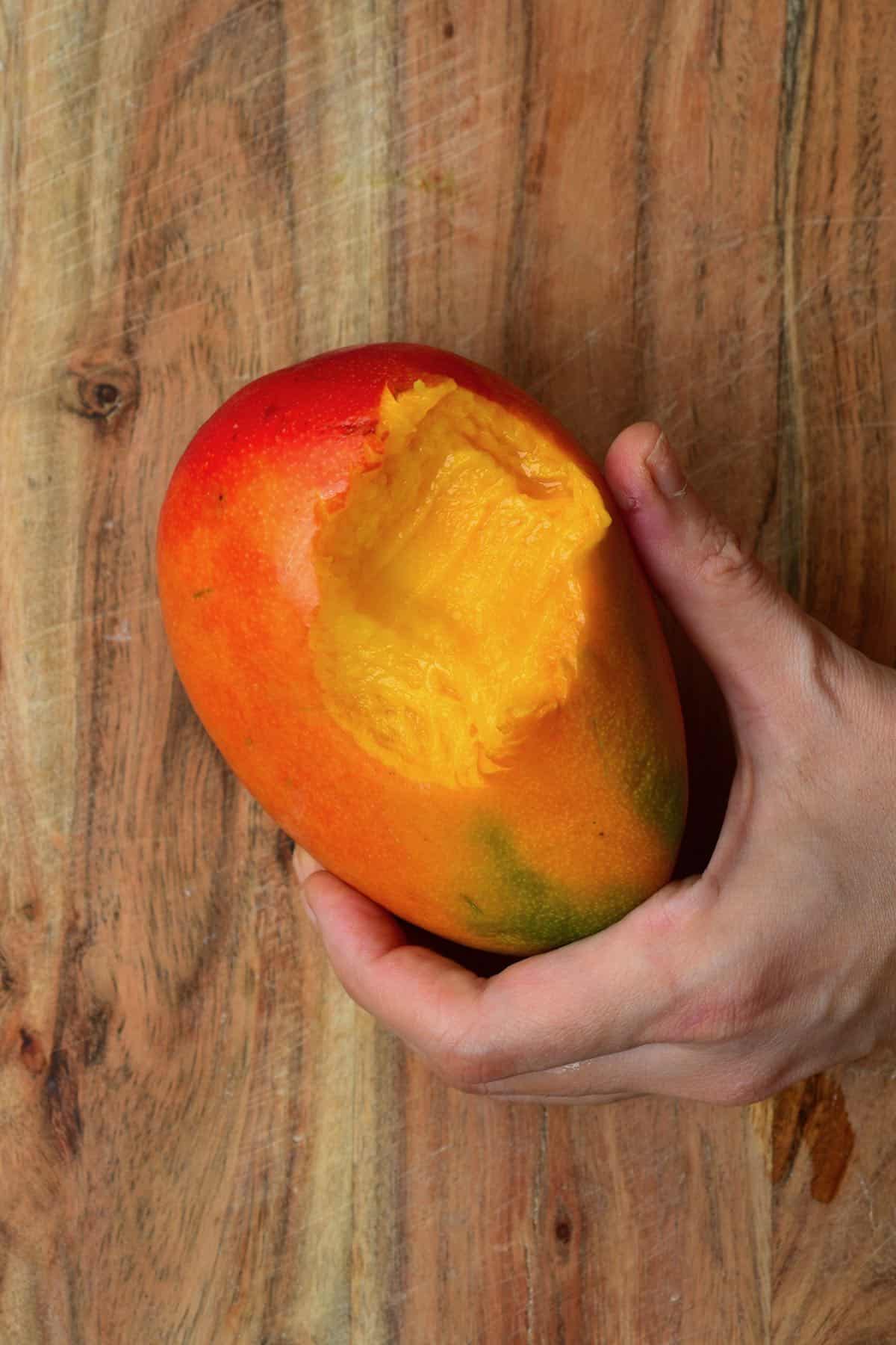 A mango with a bite in it