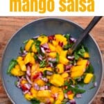 A bowl with mango salsa and a spoon