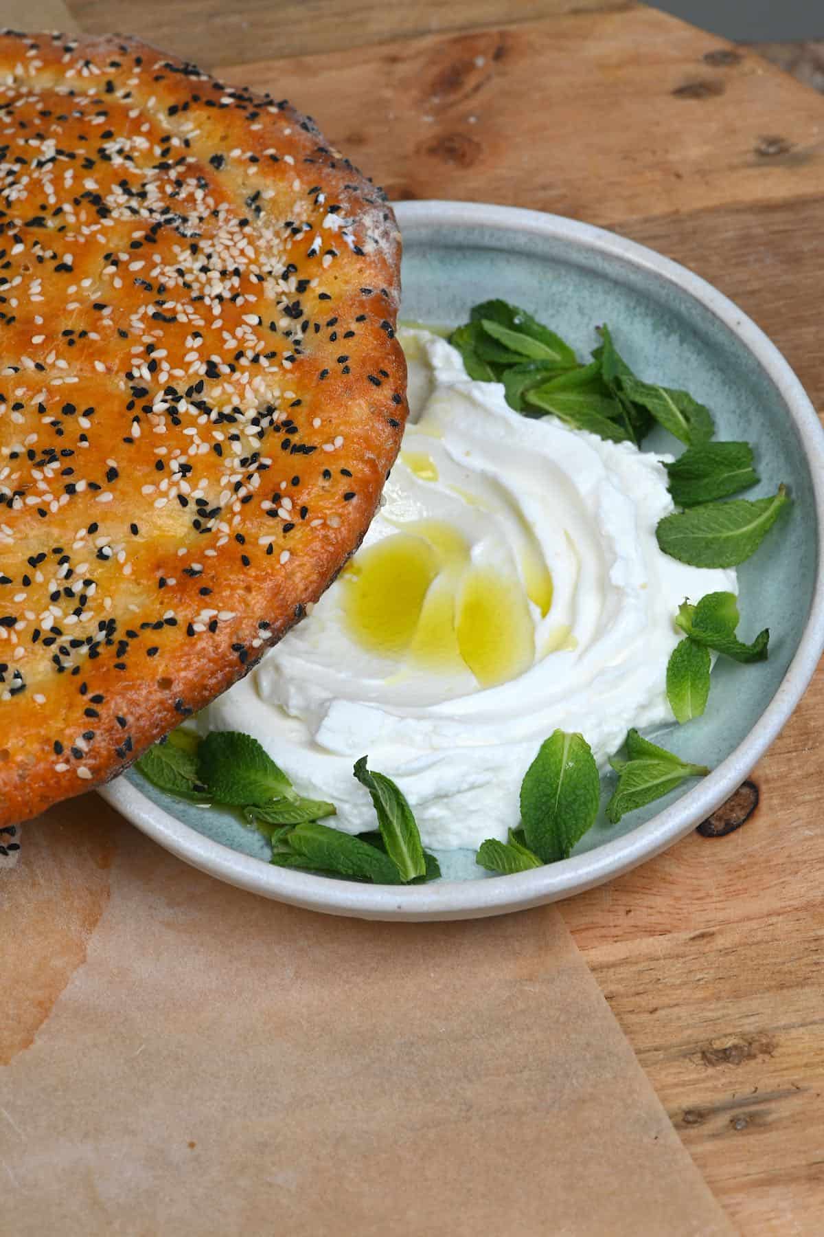 Pide bread and a bowl with labhen and mint leaves