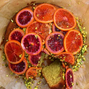Blood Orange Cake with Pistachios with a piece sliced off