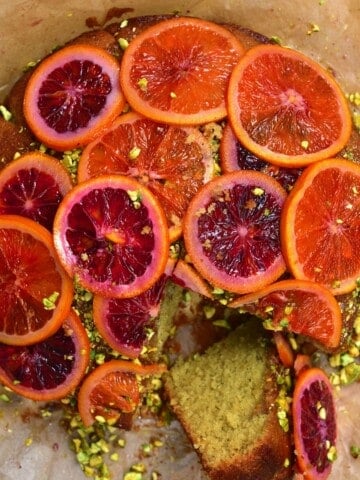 Blood Orange Cake with Pistachios with a piece sliced off