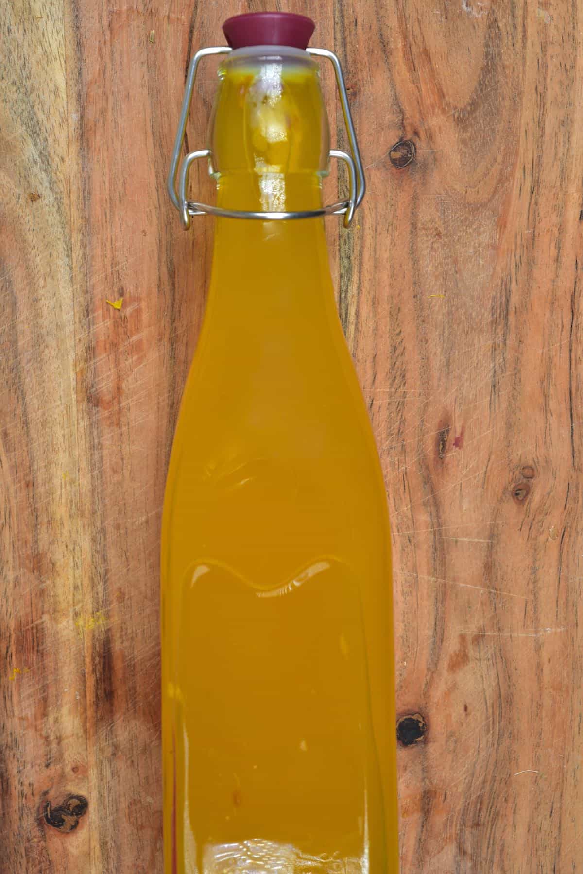 A bottle with pineapple tea laying on a wooden board