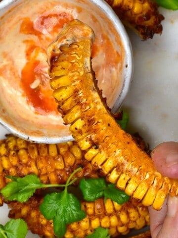 Dipping a spicy corn rib into chili mayo