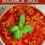 Vegan bolognese sauce in a bowl topped with a couple basil leaves