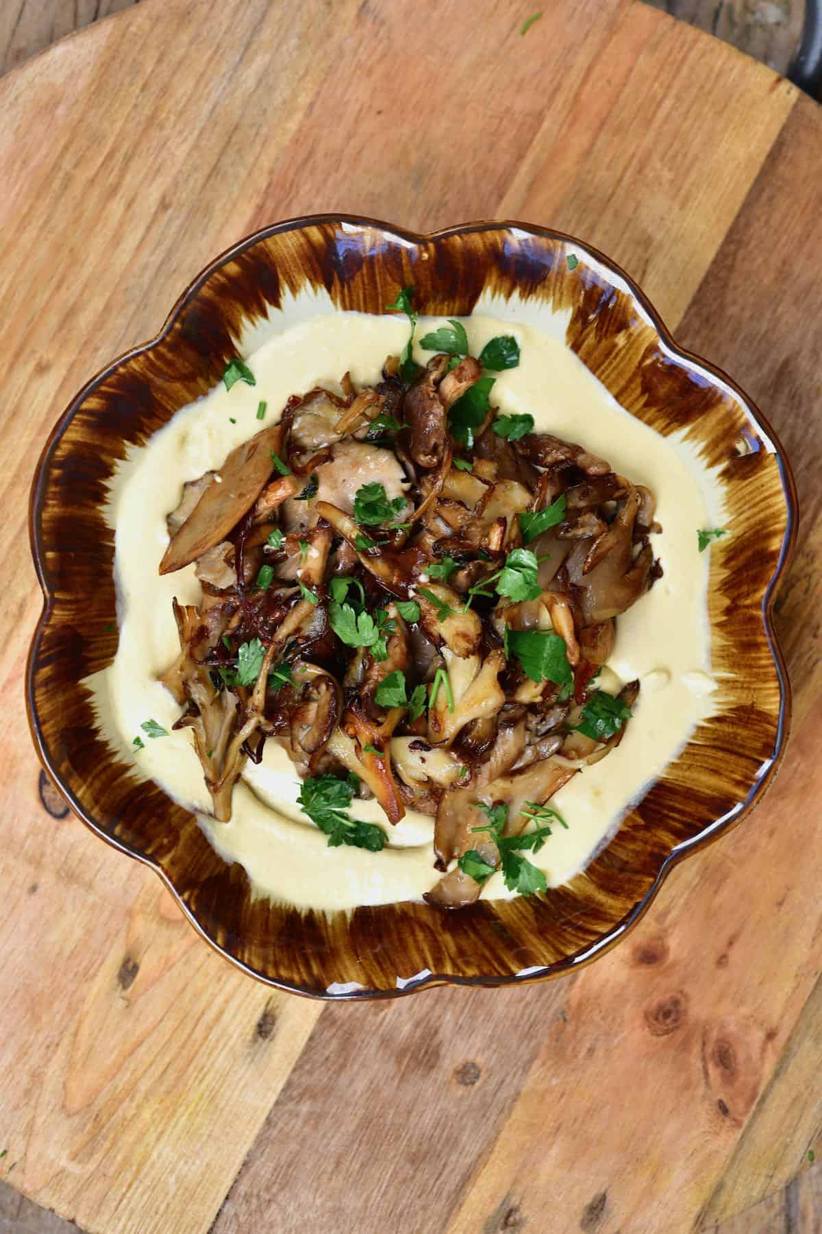 Cooked mushrooms served over hummus