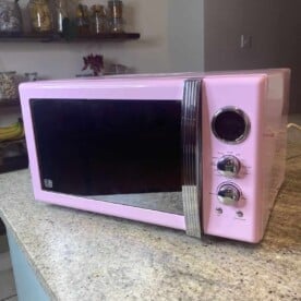 A clean pink microwave on a kitchen island