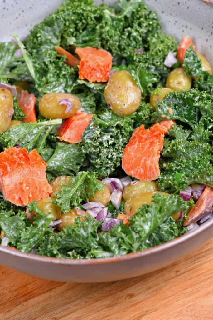 A bowl with potato kale and salmon salad