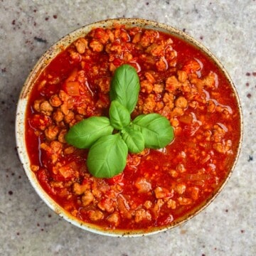 Vegan Bolognese sauce in a bowl with basil leaves on top