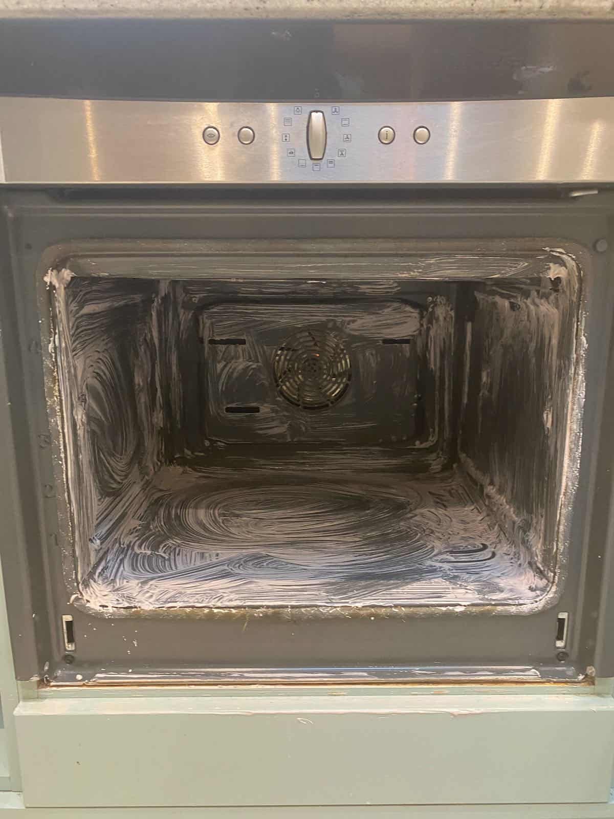 An empty oven being cleaned with baking soda