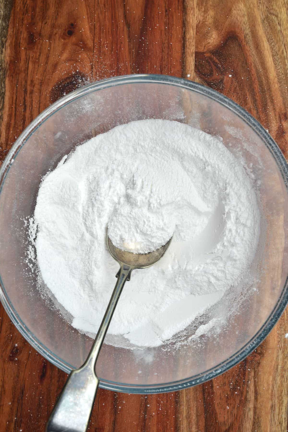 A spoon in a bowl with powdered sugar