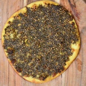Baked manakish zaatar placed on a wooden board