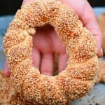 A hand holding a baked simit - 26