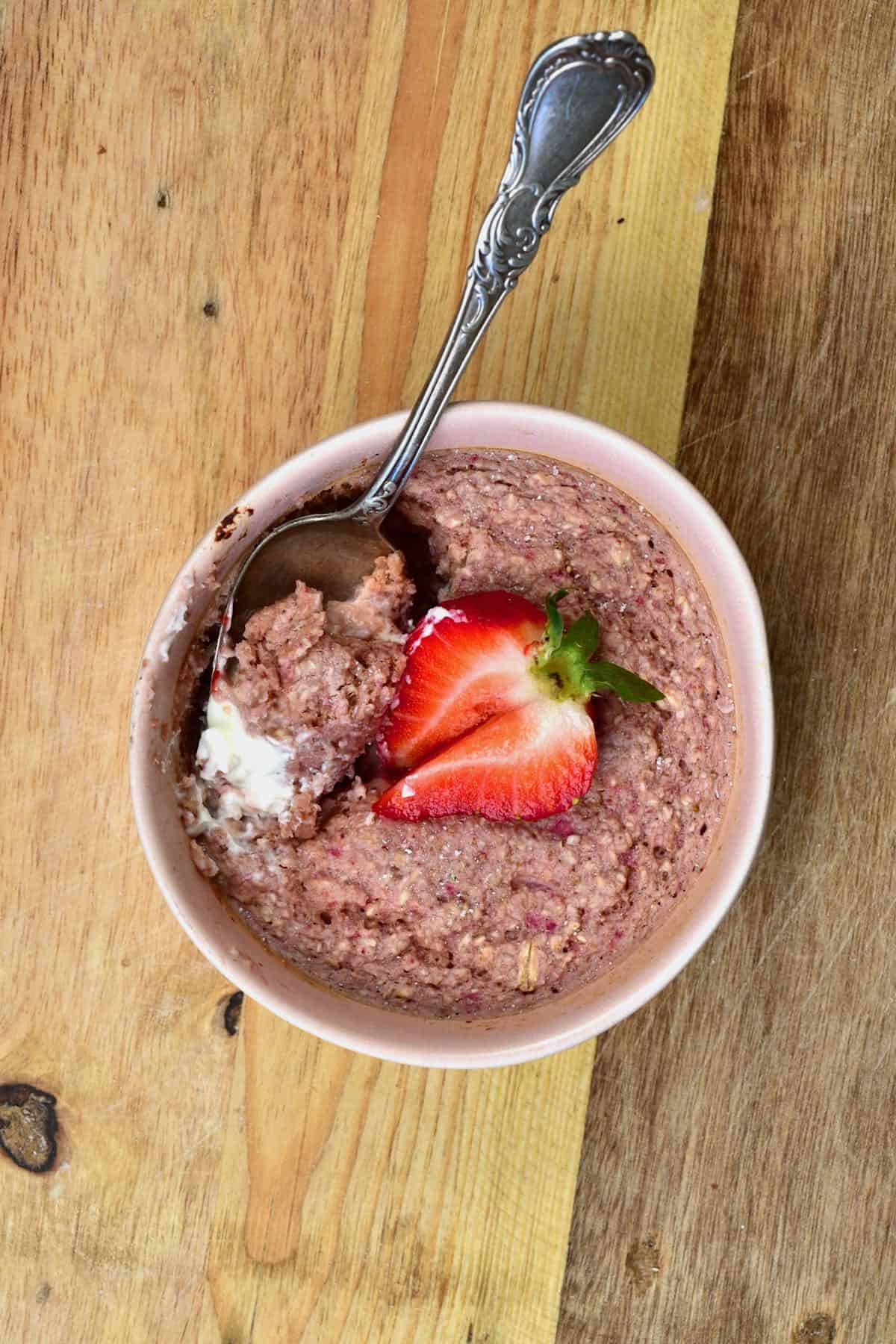 A spoon digged into strawberry baked oats