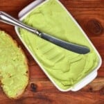 Avocado butter in a butter dish with a knife and toast on the side - 19
