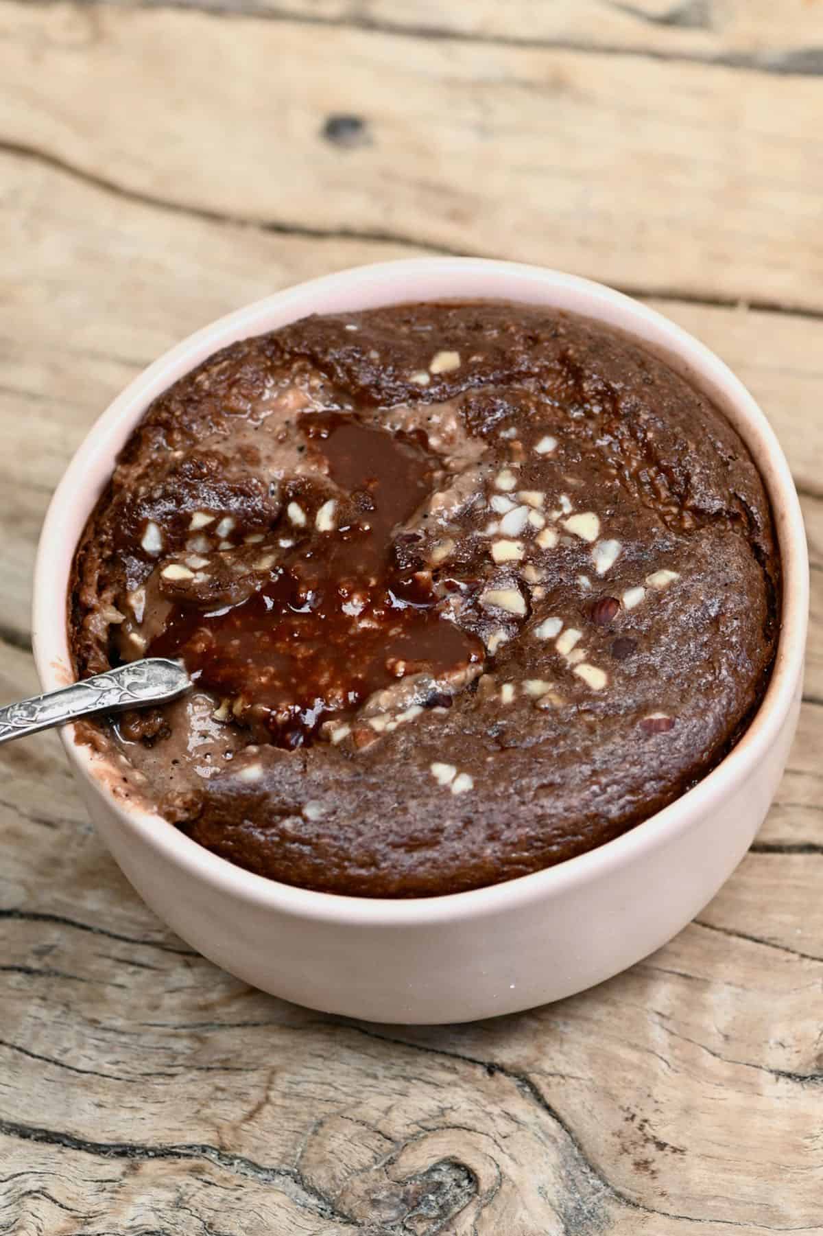 Baked chocolate oatmeal with spoon dipped in the bowl