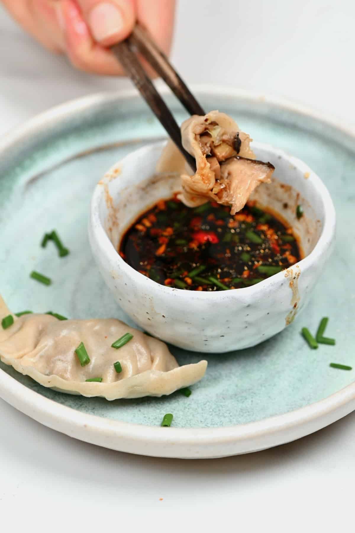 Dipping dumpling in sauce