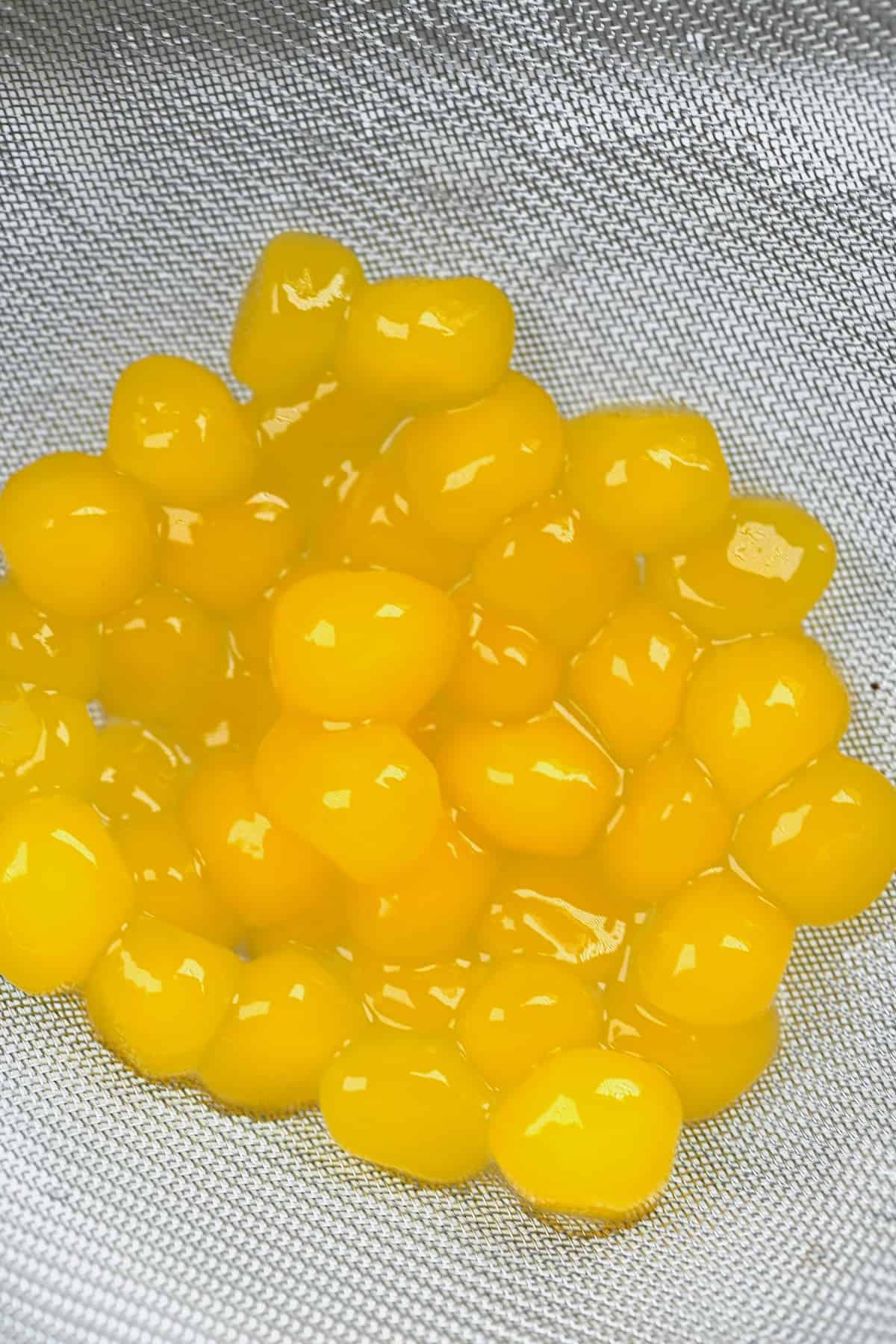 Mango tapioca pearls in a colander