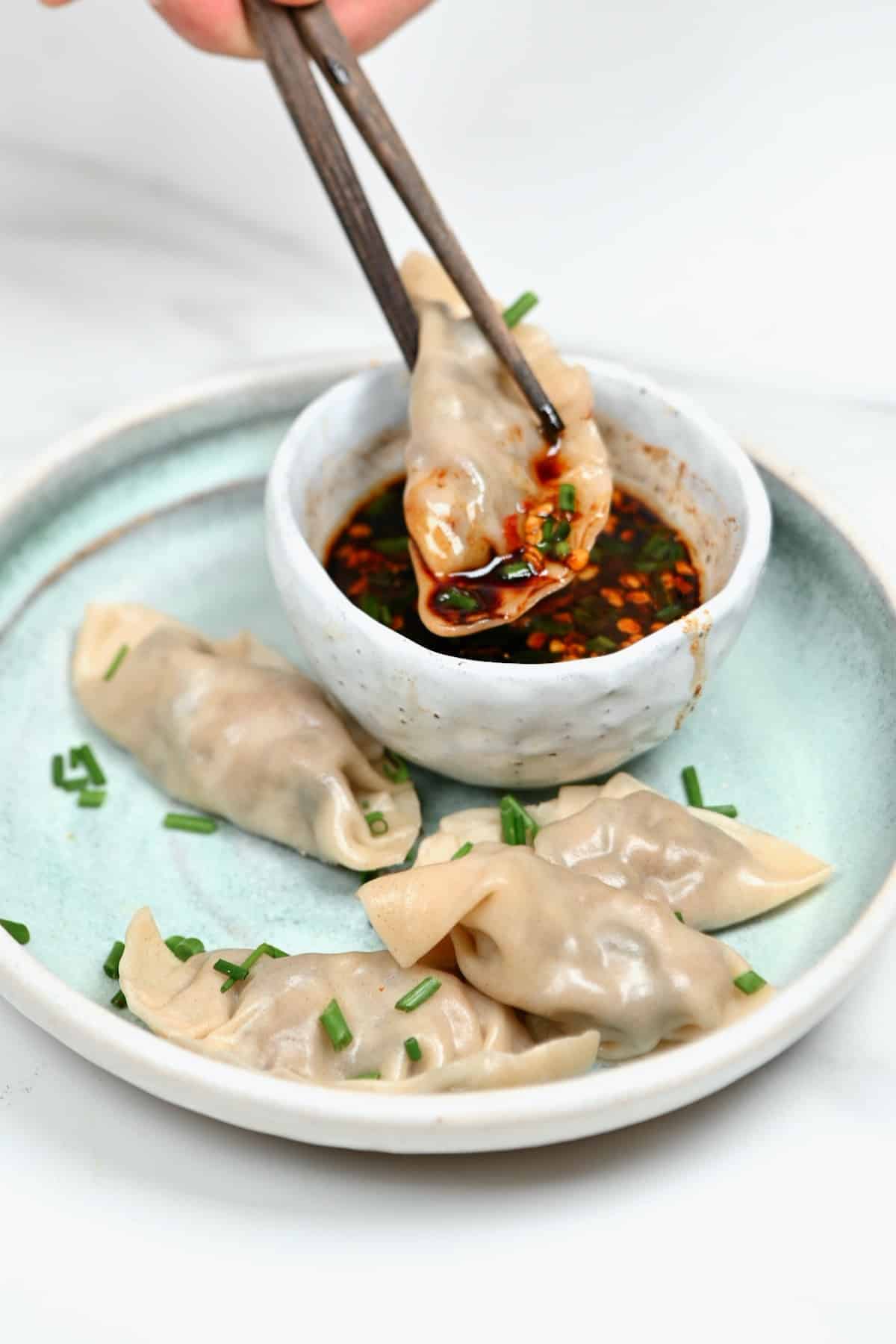 Dipping a dumpling into chili sauce