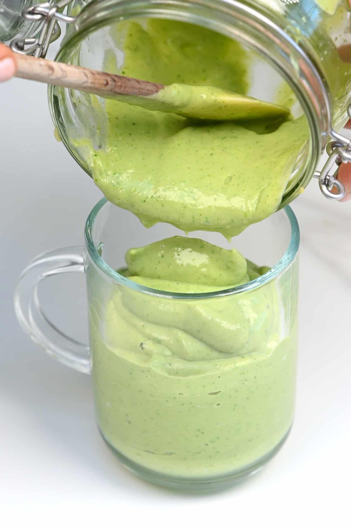 Pouring avocado smoothie in a glass