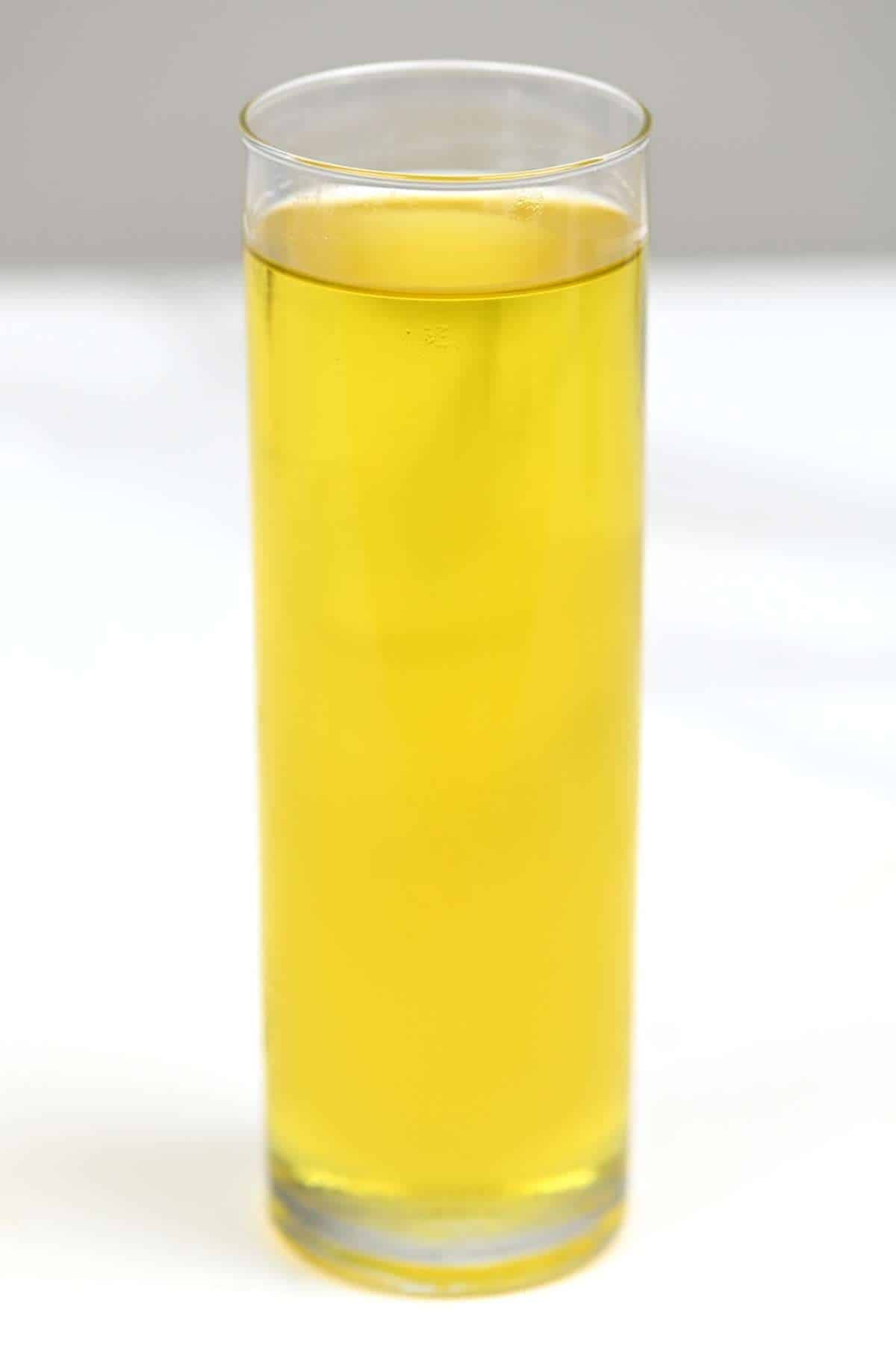 A tall galss with olive oil