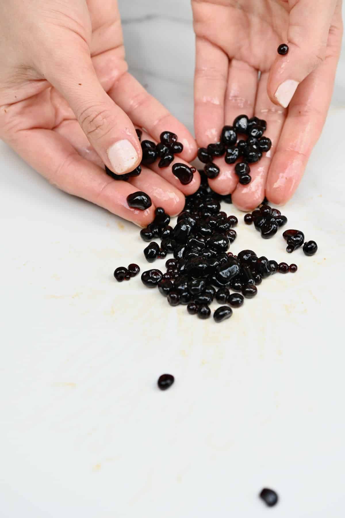 Hands showing balsamic caviar