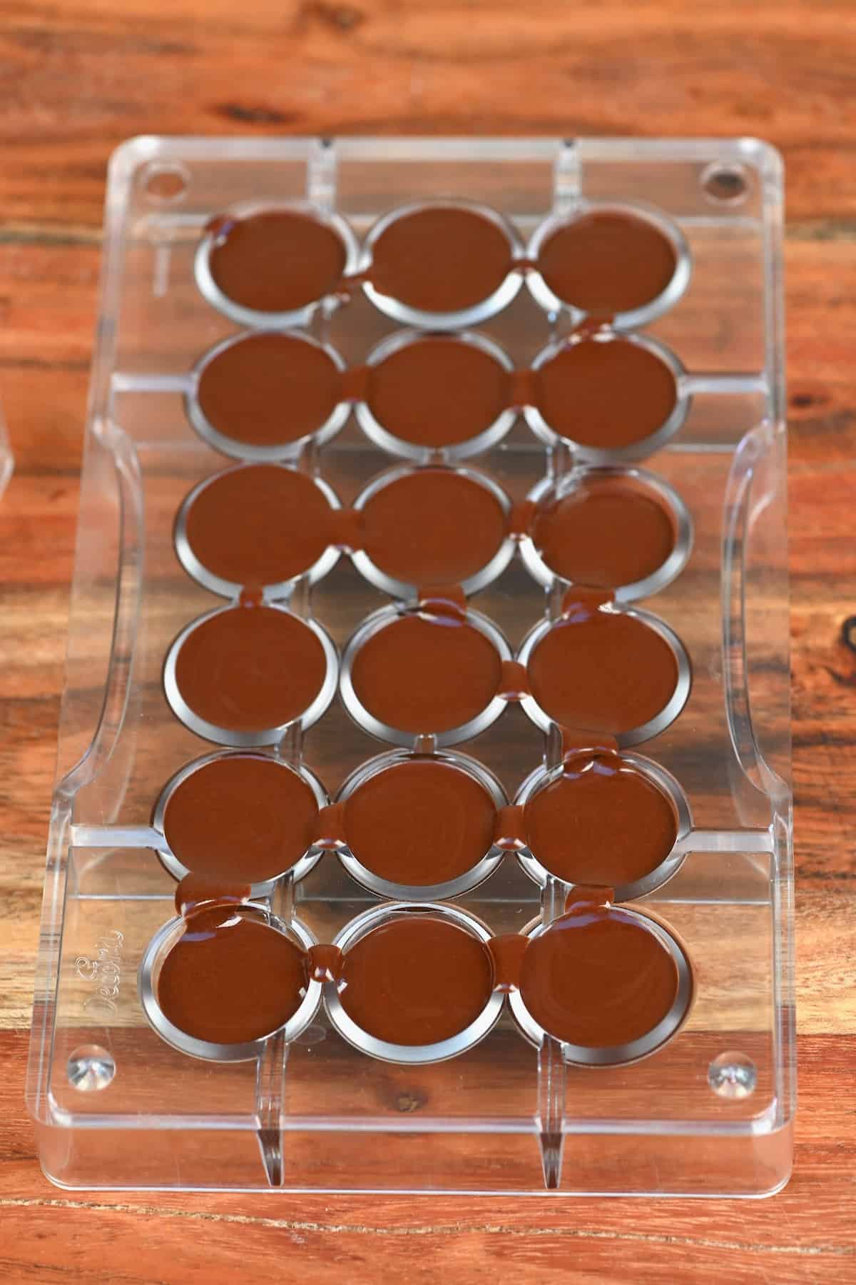Melted chocolate poured in round molds