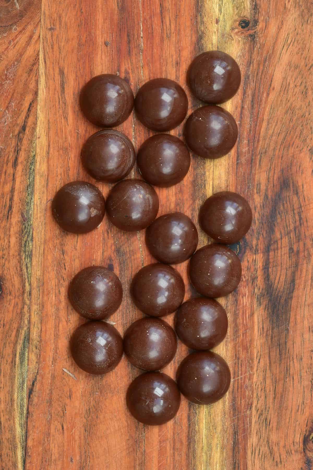 Round chocolates on a flat wooden surface