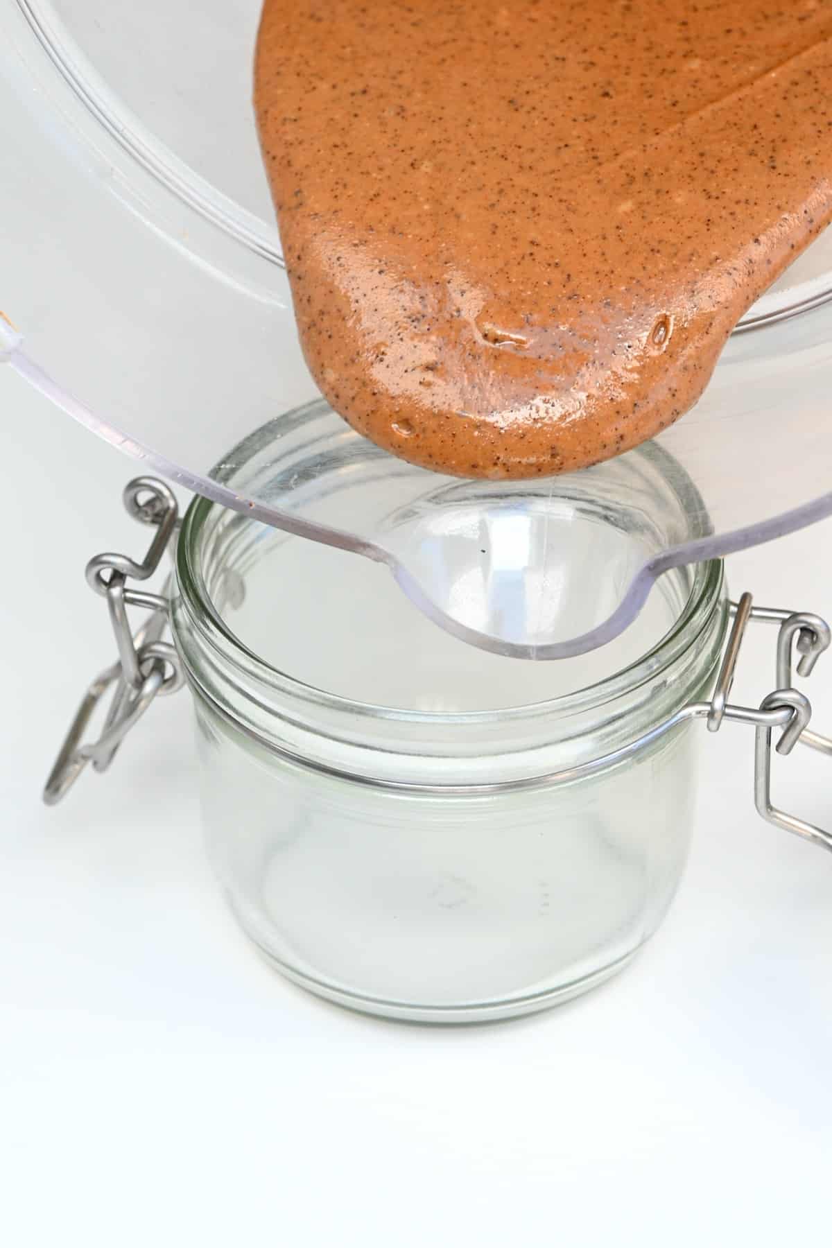 Pouring coffee peanut butter in a jar