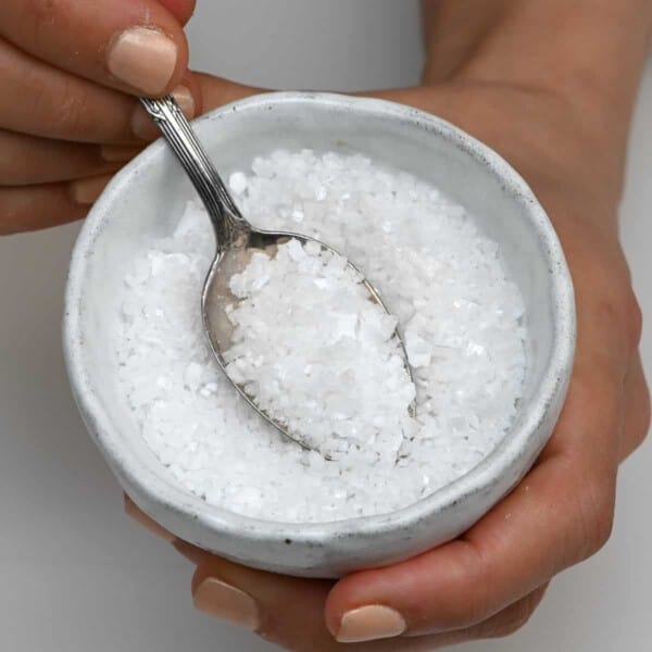 A bowl and spoonful of homemade flaky salt