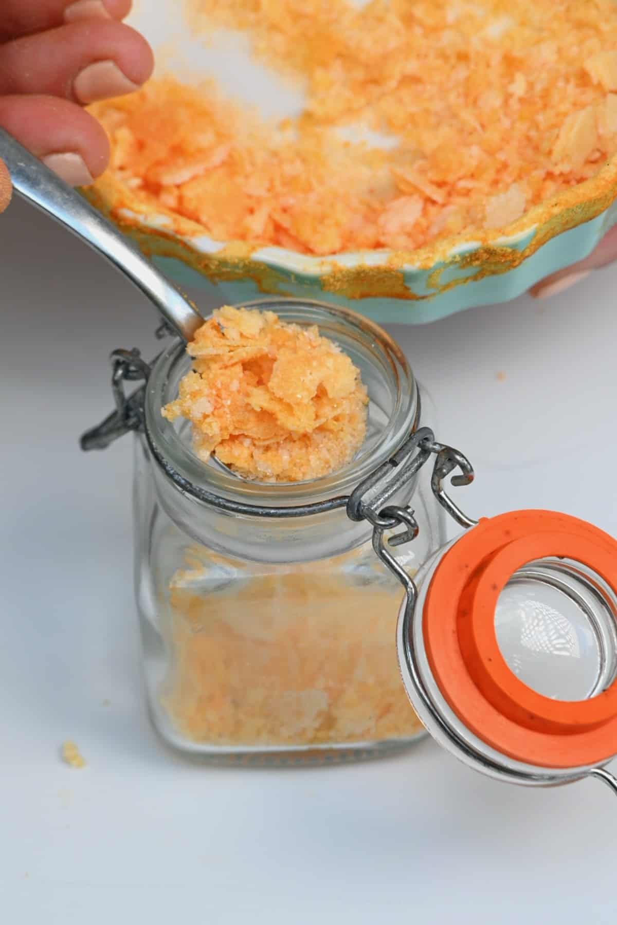 Filling a small jar with saffron flaky salt