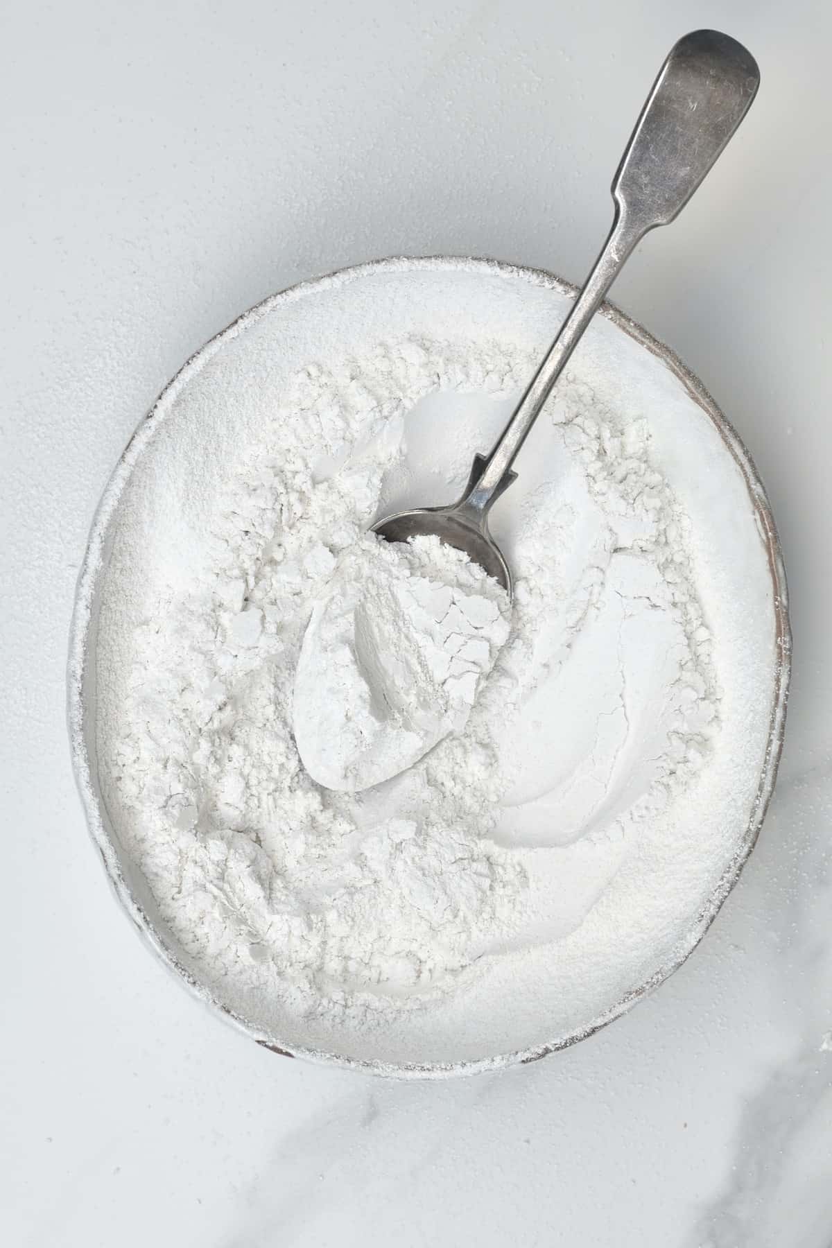 A spoon in a bowl with flour starch
