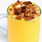 Mango lassi in a glass topped with granola