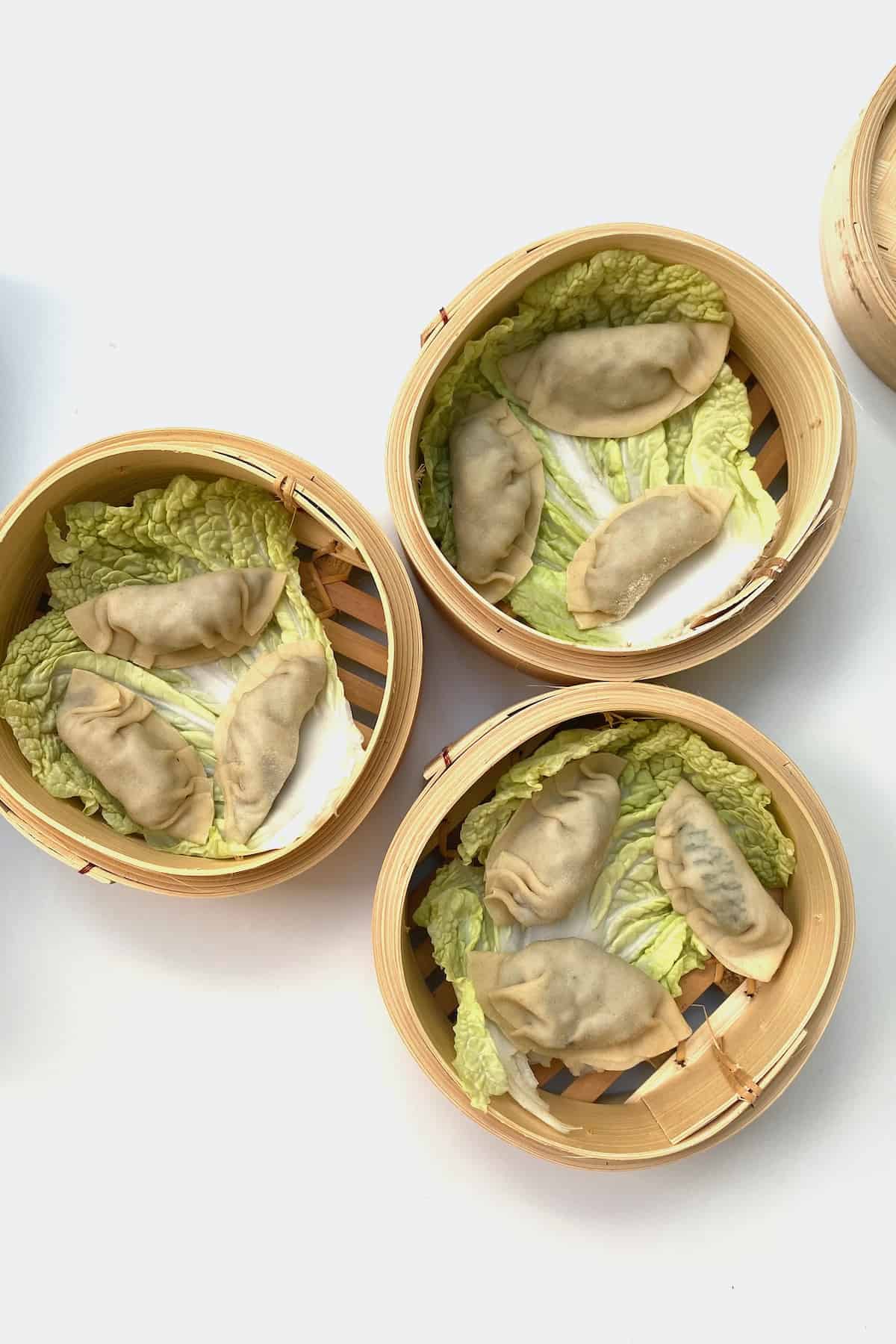 Dumplings ready to be steamed in a bamboo basket