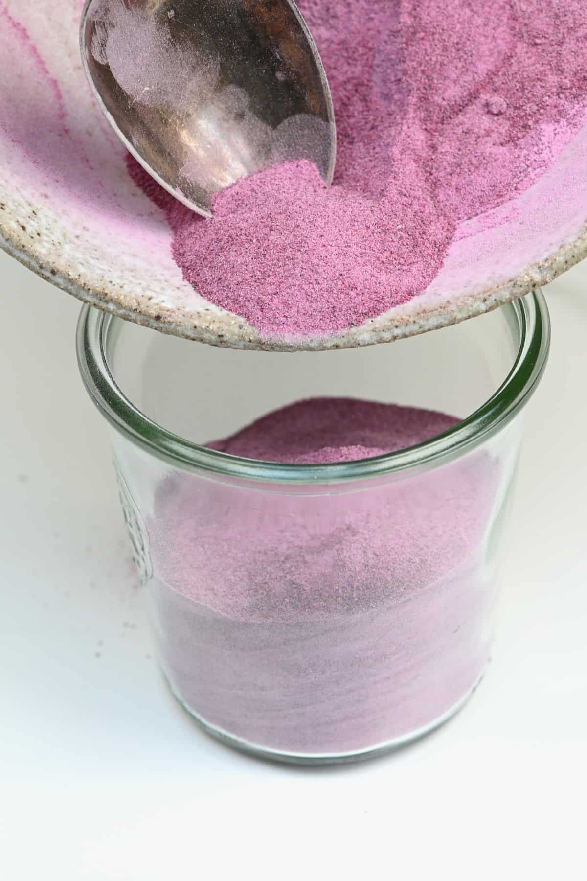 Transferring purple potato powder to a jar