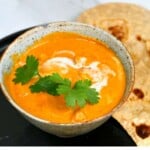 Tofu butter chicken in a bowl and roti next to it