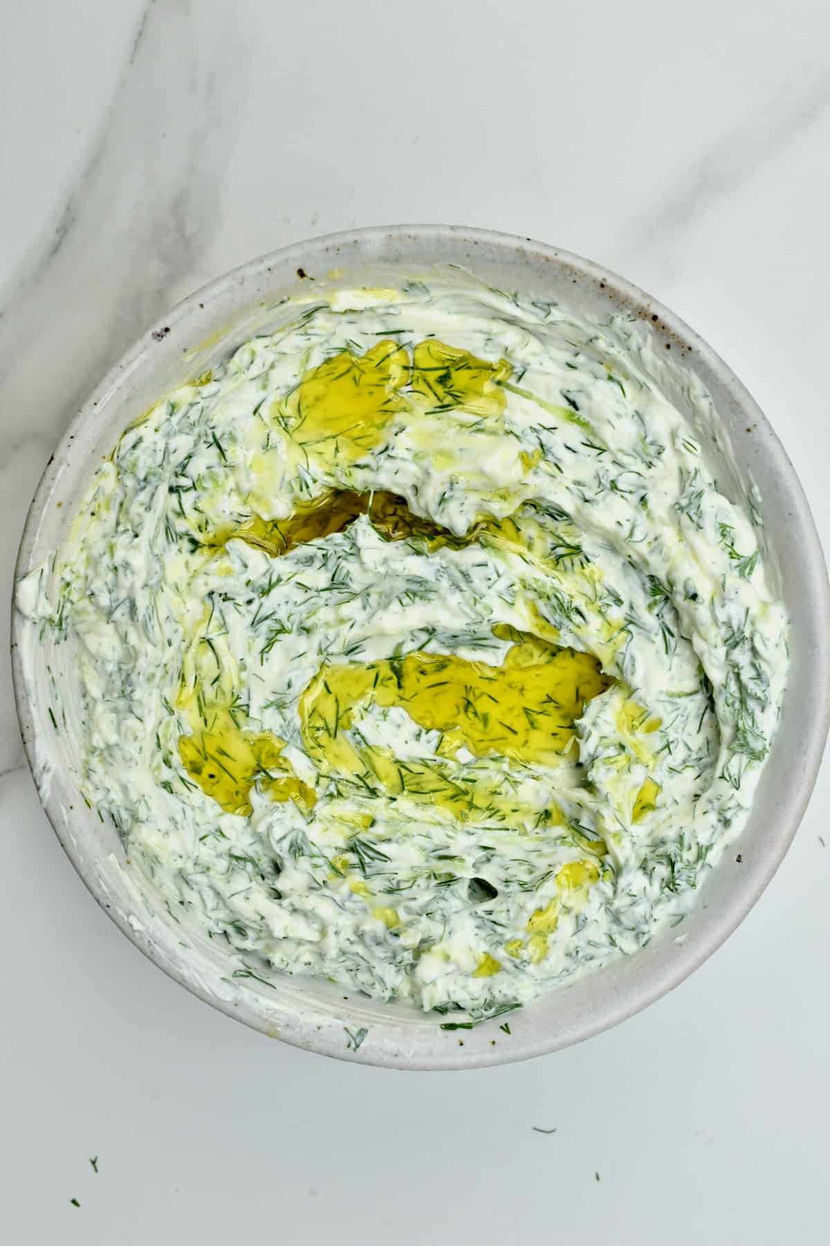 Homemade tzatziki topped with olive oil in a bowl