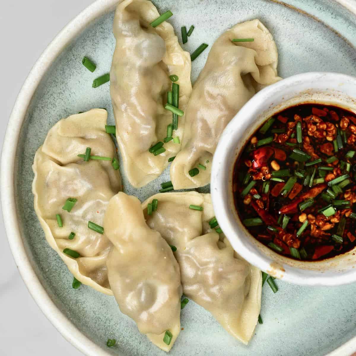 Mushroom dumplings with dipping sauce on a plate