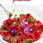 Pink beetroot pasta with basil pesto and edible flowers