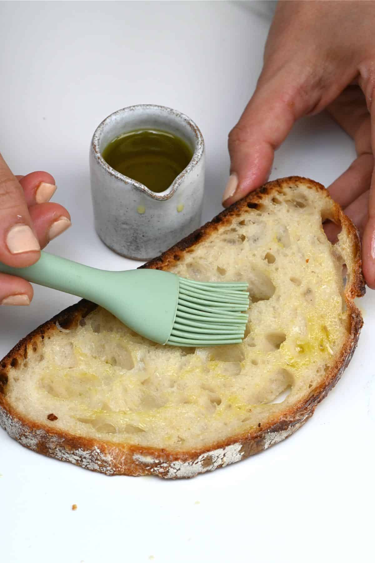 Brushing a slice of bread with oil