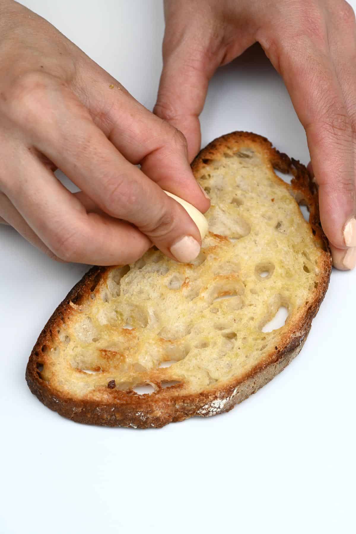 Rubbing toasted bread with garlic