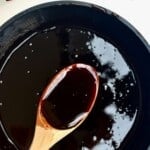 A spoonful of date syrup over a pot with the syrup