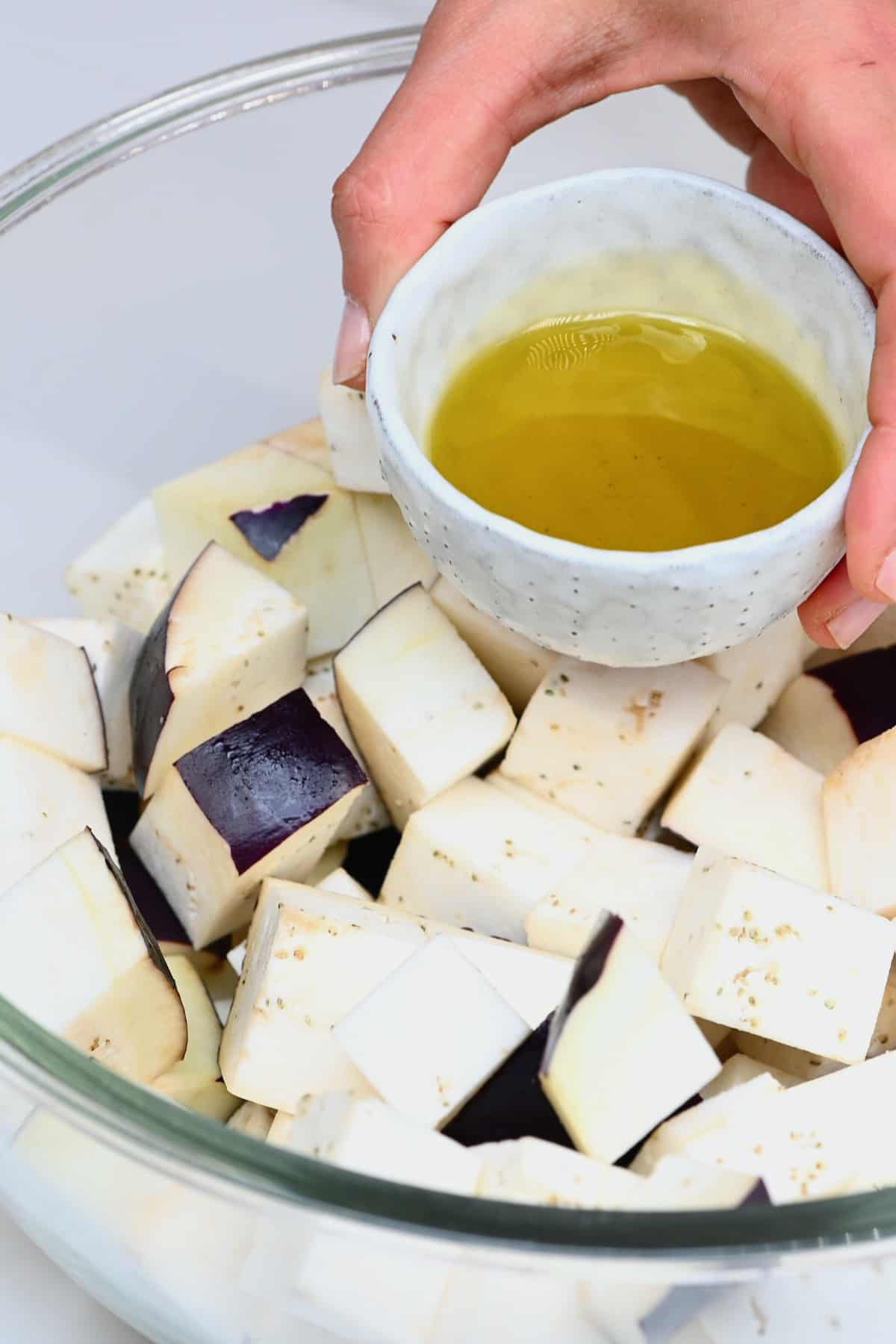 Mixing oil with eggplant cubes