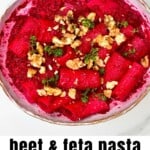 Pasta with baked feta and beet pasta sauce topped with walnuts