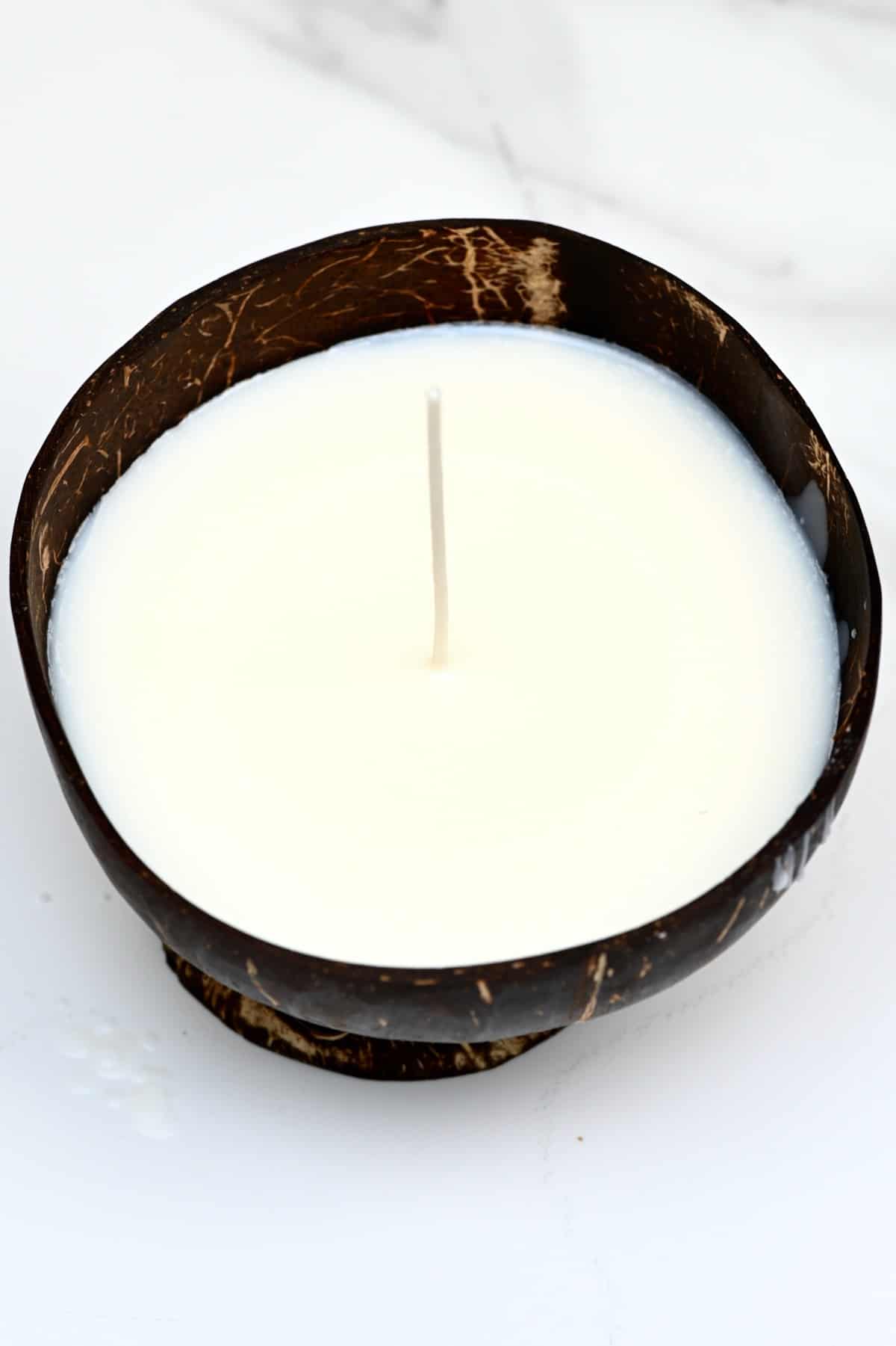 Homemade candle in a coconut bowl