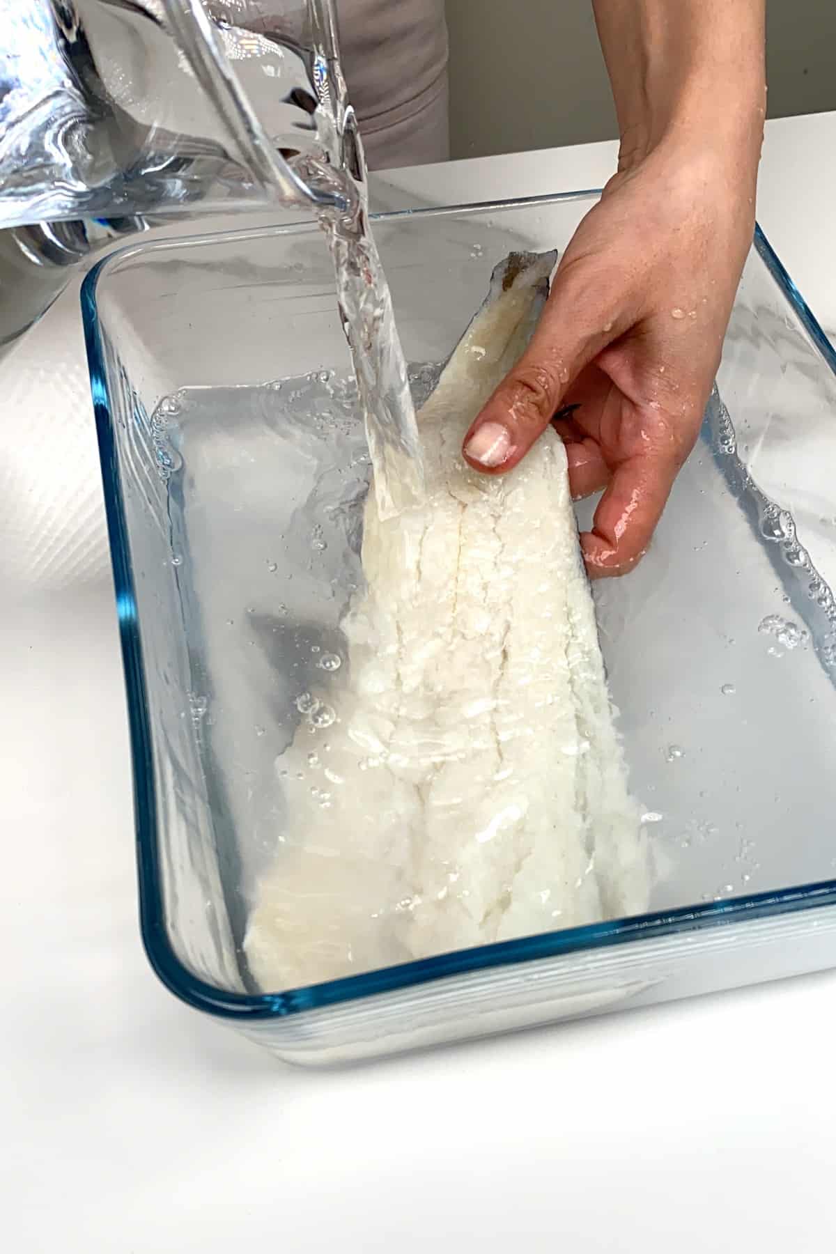 Rinsing salted cod fish with water
