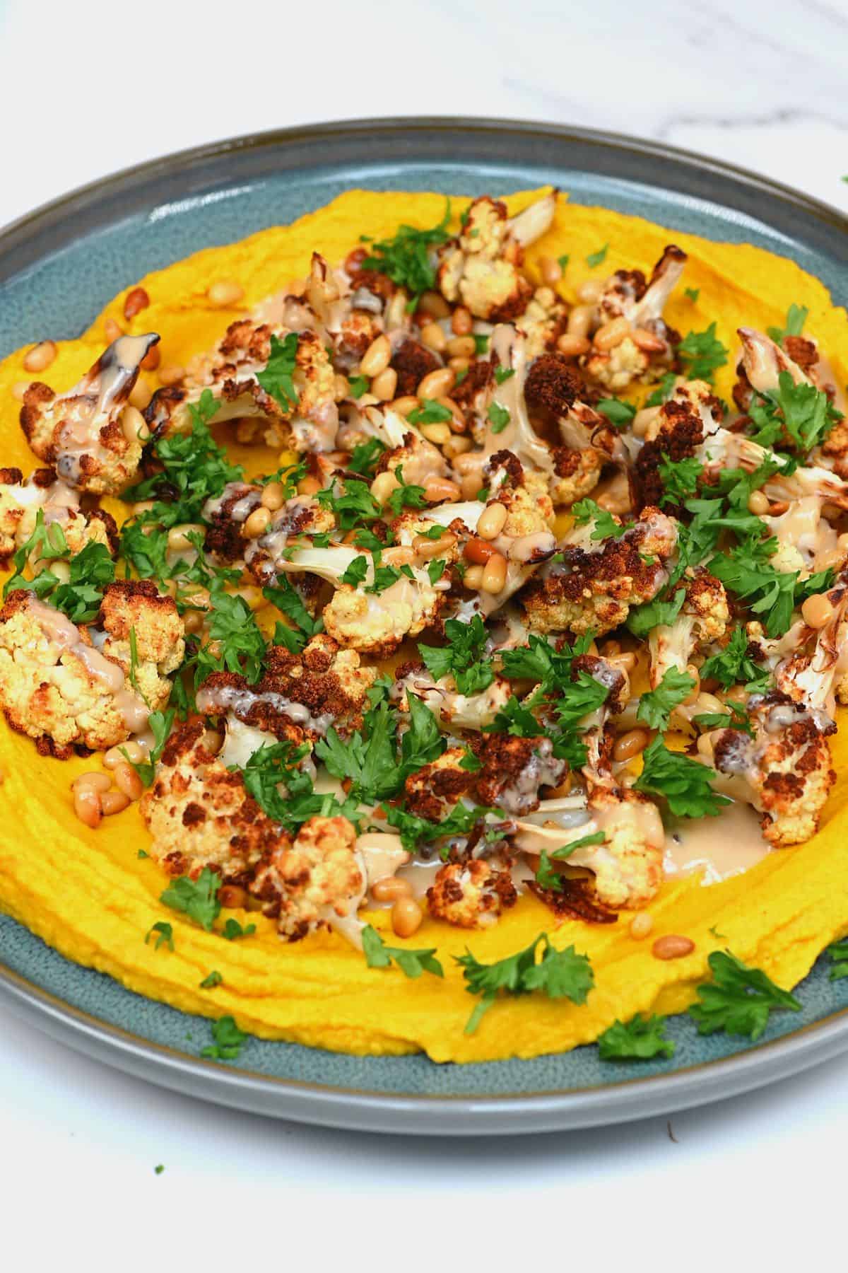 Turmeric hummus topped with cauliflower and parsley